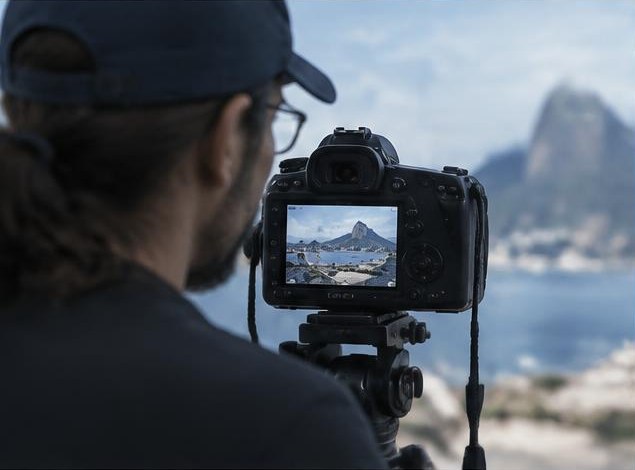 Fotógrafo compondo uma paisagem pelo visor de uma câmera